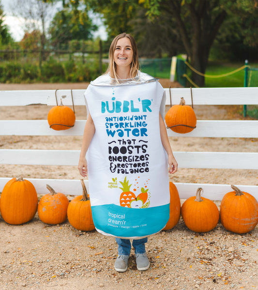 Woman in tropical can costume near pumpkins